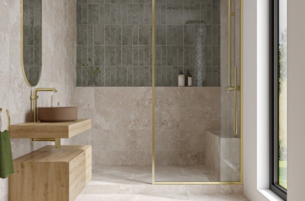 Light-filled wet room bathroom with textured green tiles, and gold fixtures.
